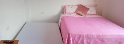 a small bedroom with a pink bed and a pillow at 1Cálido y Amarillo in Jericó