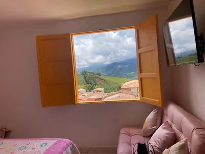 a bedroom with a window with a view of a mountain at 1Cálido y Amarillo in Jericó