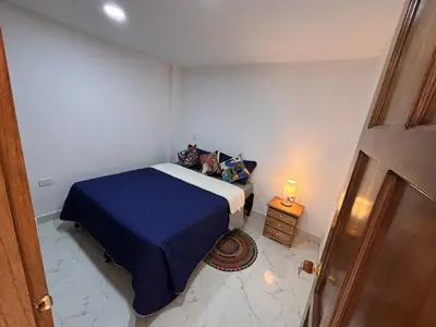 a small bedroom with a bed and a night stand at 1Cálido y Amarillo in Jericó