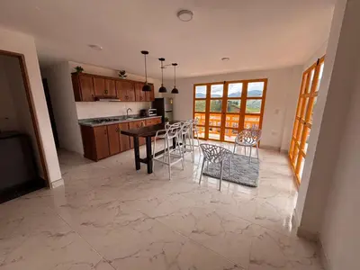 a kitchen with a table and chairs in a room at 1Cálido y Amarillo in Jericó