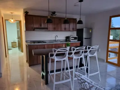 a kitchen with a counter with stools in it at 1Cálido y Amarillo in Jericó