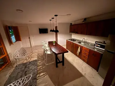 a kitchen with a wooden table and chairs in it at 1Cálido y Amarillo in Jericó