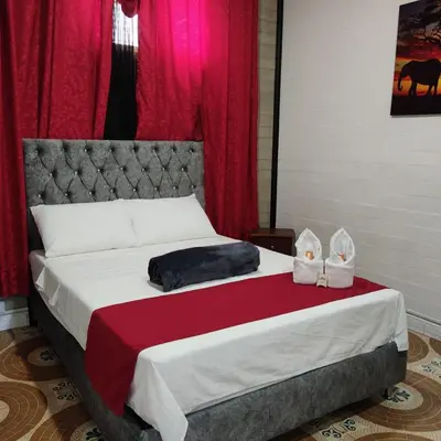 a bedroom with a bed with two shoes on it at Hotel Hollywood Paradise ZF in Rionegro