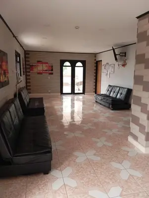 a large room with black leather furniture and a tile floor at Hotel Hollywood Paradise ZF in Rionegro