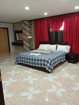a bedroom with a bed and a red curtain at Hotel Hollywood Paradise ZF in Rionegro
