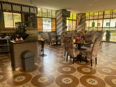 a restaurant with a table and chairs in a room at Hotel Hollywood Paradise ZF in Rionegro