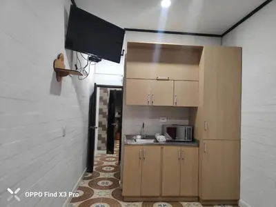 a kitchen with wooden cabinets and a microwave at Hotel Hollywood Paradise ZF in Rionegro