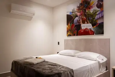 a bed in a room with a painting on the wall at Hotel Yuma in La Dorada