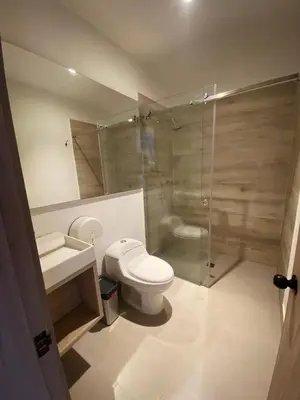 a bathroom with a toilet and a glass shower at Hotel Yuma in La Dorada