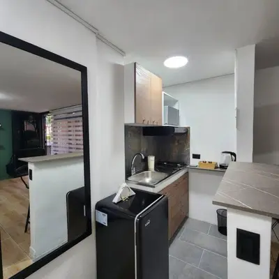 a small kitchen with a sink and a counter at Loft with bathtub in Laureles in Medellín