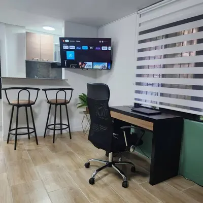 an office with a desk and three bar stools at Loft with bathtub in Laureles in Medellín