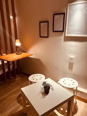 a white table and two stools in a room at Renacer, Poblado Manila in Medellín