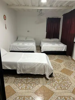 two beds in a room with a floor at Alojamiento Doradal Antioquía, en el santorini colombiano, la aldea in Doradal