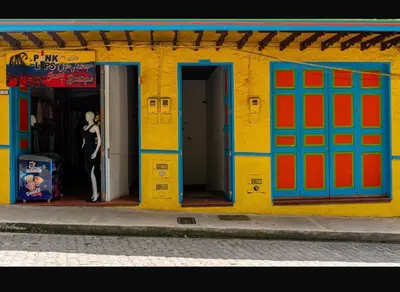 a building with colorful doors and a man standing in the doorway at Suite Master in Jericó
