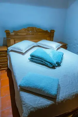 a bed with blue pillows and blue towels on it at Suite Master in Jericó