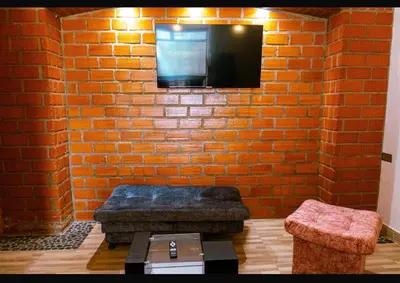 a living room with a brick wall with a tv at Suite Encanto in Jericó