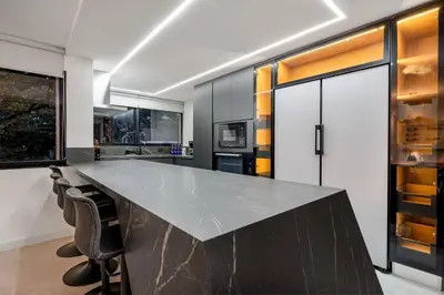 a kitchen with a large counter with chairs around it at Private Sauna Jacuzzi Billiard Gym Luxury Retreat in El Poblado