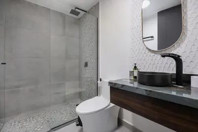 a bathroom with a toilet and a sink and a mirror at Private Sauna Jacuzzi Billiard Gym Luxury Retreat in El Poblado
