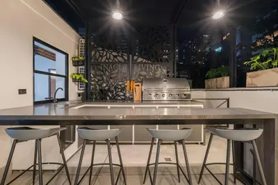 a kitchen with a large counter with four stools at Private Sauna Jacuzzi Billiard Gym Luxury Retreat in El Poblado