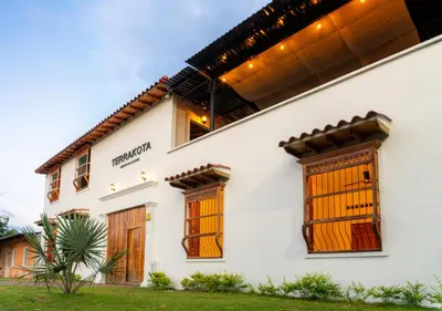 a white house with wooden doors and windows at TERRAKOTA Heritage House in Mariquita