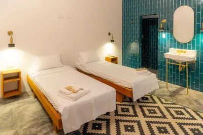 two twin beds in a room with a sink at TERRAKOTA Heritage House in Mariquita