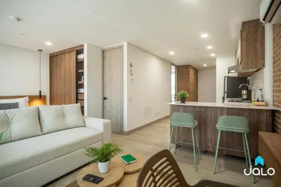 a living room with a couch and a kitchen at Kyux Studios by Jalo - Laureles in Medellín