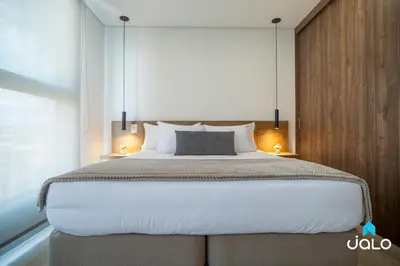 a bedroom with a large bed with two lamps at Kyux Studios by Jalo - Laureles in Medellín