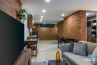 a living room and kitchen with a brick wall at Kyux Studios by Jalo - Laureles in Medellín