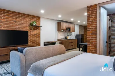 a room with a bed and a couch and a tv at Kyux Studios by Jalo - Laureles in Medellín