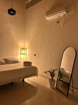 a bedroom with a bed and a mirror and a fan at Clandestino - Hotel Boutique in La Dorada
