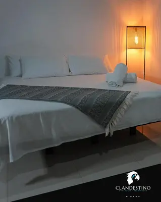 a large white bed with a blanket on it at Clandestino - Hotel Boutique in La Dorada
