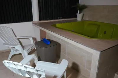 a bathroom with a green tub and two chairs at Clandestino - Hotel Boutique in La Dorada
