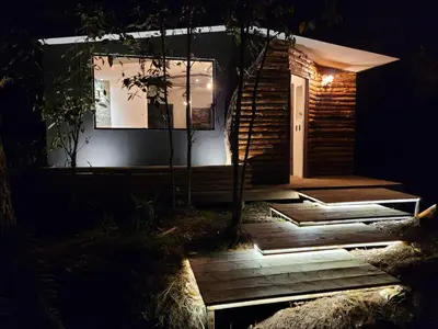 a house with a staircase leading to the door at night at Cabaña Aventurina- La pascana Ecolodge Entorno natural excepcional, conexión con la naturaleza y avistamiento de aves, Ubicado a 3km del metrocable y Parque Arvi, Guarne in Mazo