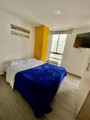 a bedroom with a bed with a blue blanket at Apartamento , frente a la universidad autónoma , edificio urban in Manizales