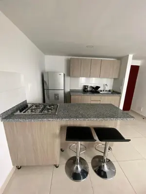 a kitchen with a counter and two bar stools at Apartamento , frente a la universidad autónoma , edificio urban in Manizales