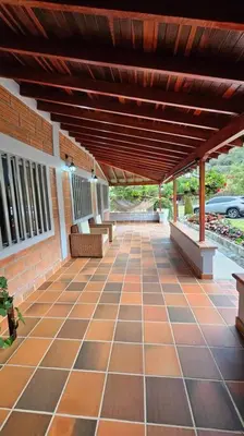 an outdoor patio with benches and a wooden roof at Casa campestre,Guarne-Aeropuerto in Guarne