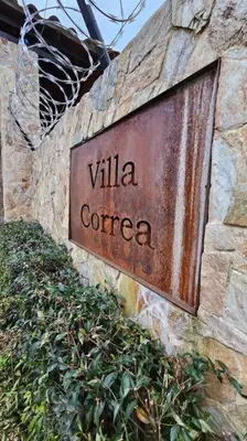 a sign on the side of a stone wall at Casa campestre,Guarne-Aeropuerto in Guarne