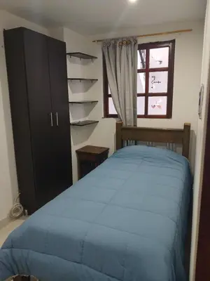a bedroom with a blue bed and a window at Comodidad y confort in Olaya Herrera Airport