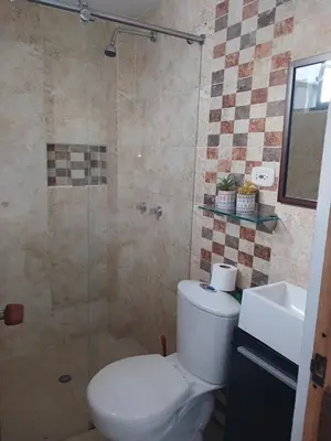 a bathroom with a toilet and a glass shower at Comodidad y confort in Olaya Herrera Airport