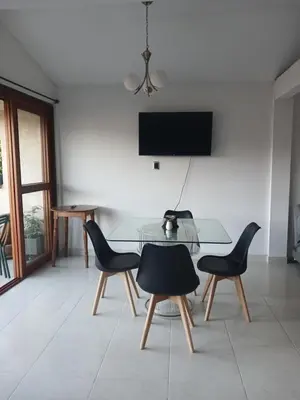 a dining room with a glass table and two chairs at Comodidad y confort in Olaya Herrera Airport