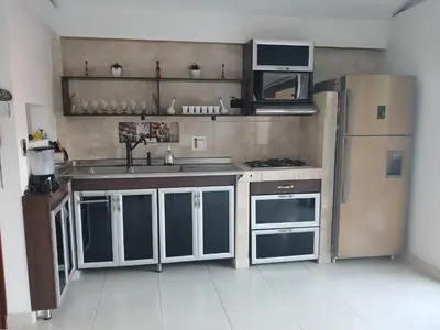 a kitchen with a sink and a refrigerator at Comodidad y confort in Olaya Herrera Airport