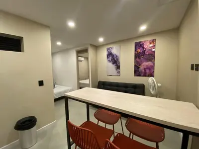 a room with a table and chairs and a bed at Hermoso apartamento en el poblado in Medellín