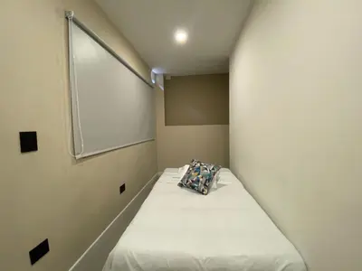 a small bed in a small room with a window at Hermoso apartamento en el poblado in Medellín