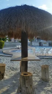 a table with a straw umbrella on the beach at Santa Fe Relax in Santa Fe de Antioquia