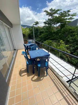 a patio with tables and chairs on a balcony at Santa Fe Relax in Santa Fe de Antioquia