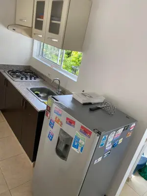 a kitchen with a refrigerator with magnets and a sink at Santa Fe Relax in Santa Fe de Antioquia