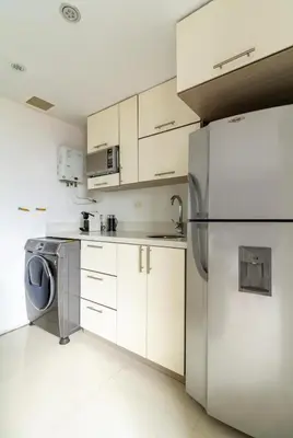 a kitchen with white cabinets and a washer and dryer at Aparta loft in Envigado