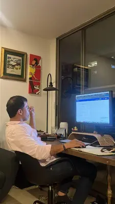 a man sitting at a desk with a computer at Babakan in Guatapé