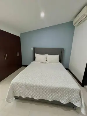 a bedroom with a large white bed with two pillows at Private Jacuzzi 3 Bedroom apartment in Provenza cartagena in Medellín