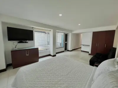 a large bedroom with a bed and a flat screen tv at Private Jacuzzi 3 Bedroom apartment in Provenza cartagena in Medellín